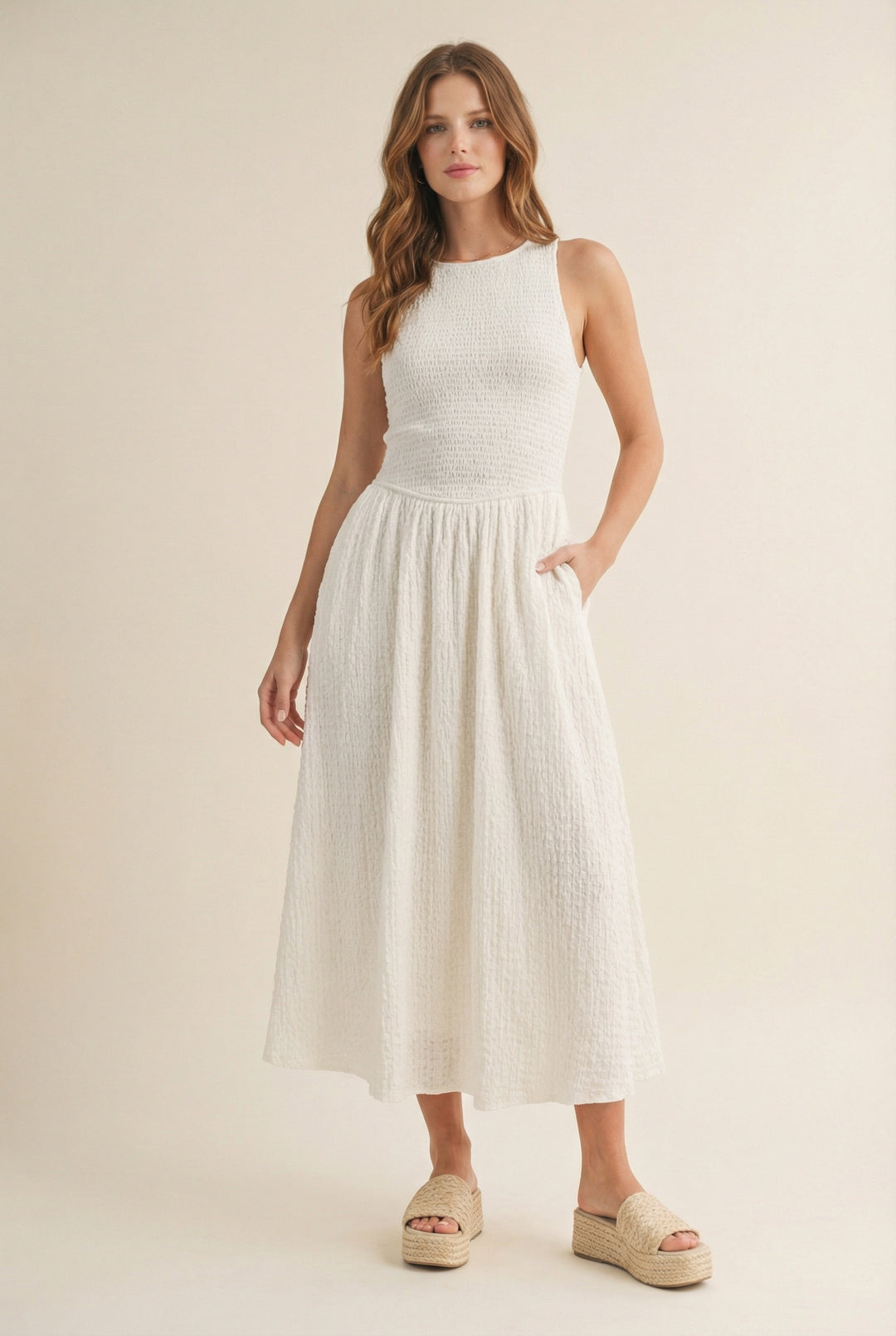 Woman wearing a white sleeveless dress on a beige background