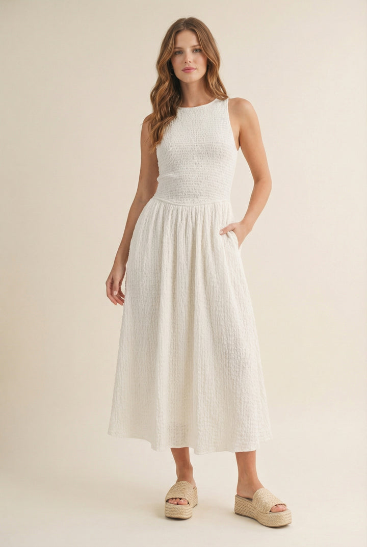 Woman wearing a white sleeveless dress on a beige background